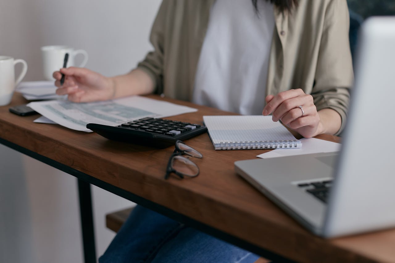 A lady with a pen in hand writing down her personal finance strategies as a beginner.